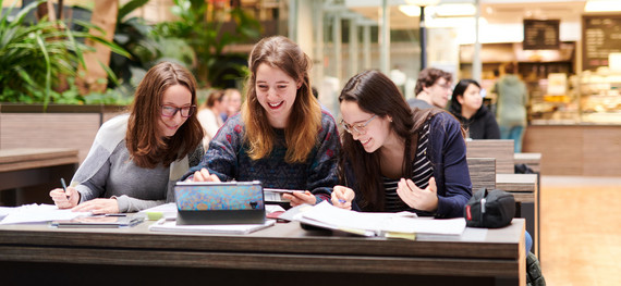 Drei Studentinnen der Humanmedizin arbeiten in der Osthalle des Uniklinikums an einer Präsentation.