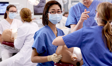 Zahnmedizinstudenten mit einer Lehrattrappe