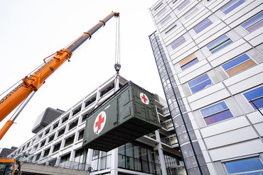 Ein Hilfe-Container schwebt am Kranhaken: Aufbau des mobilen CT Containers der Bundeswehr für die Notfalldiagnostik von COVID-19 Verdachtsfällen an der Universitätsmedizin Göttingen. 